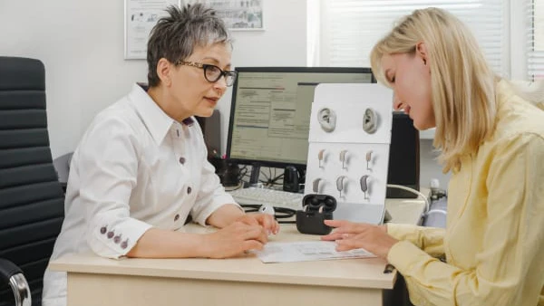 Woman comparing hearing aids at consultation.