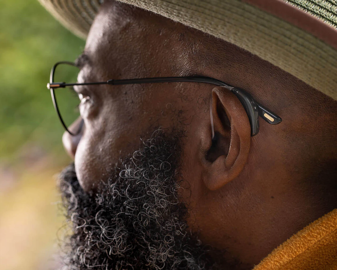 A man wearing a hearing aid and glasses.