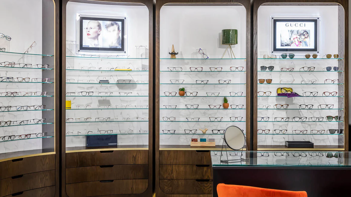 Multiple eyeglass displays arranged inside an optician's shop.