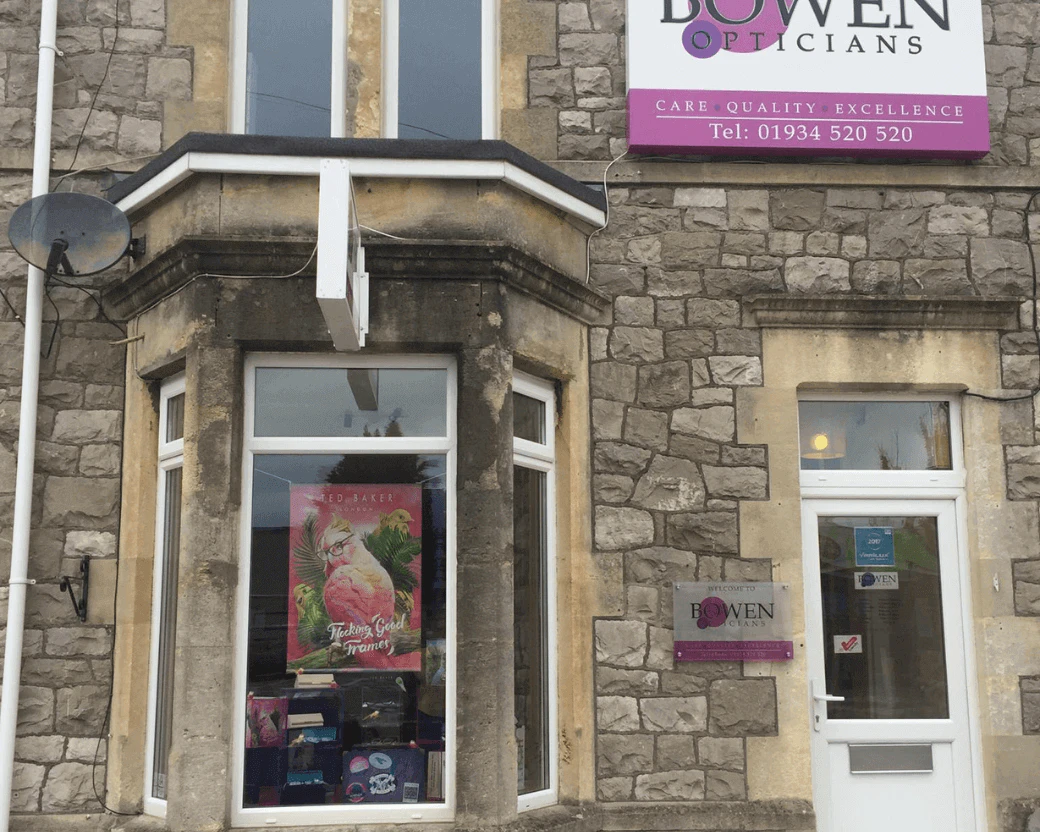Bowen Opticians, outside the stone building with a bay window and a white front door